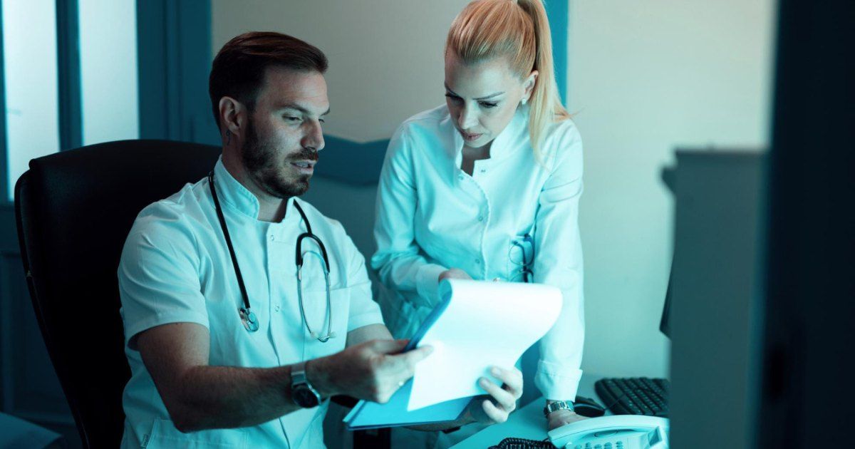 two doctors at a desk viewing patient scans 